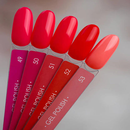 Set of gel polish samples in various red shades on a neutral background